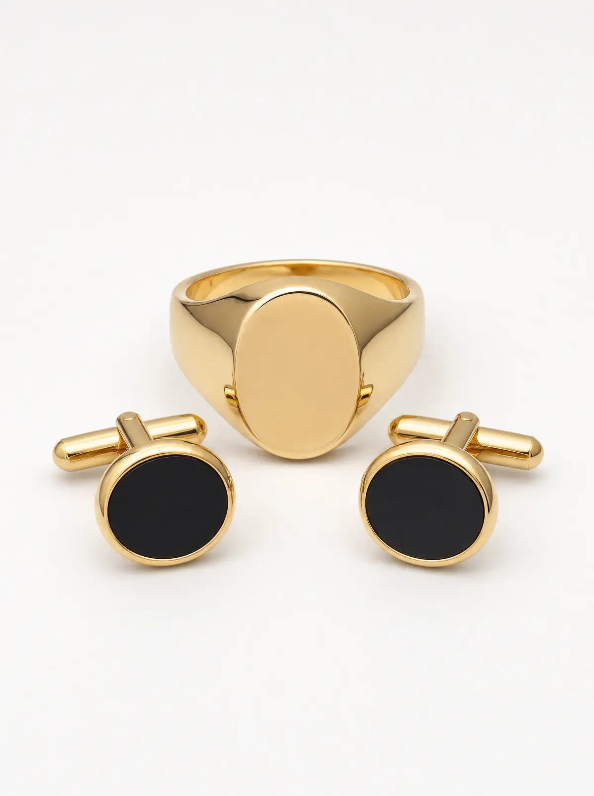 A gold signet ring and gold and onyx cufflinks on light grey (illustrative, generated)