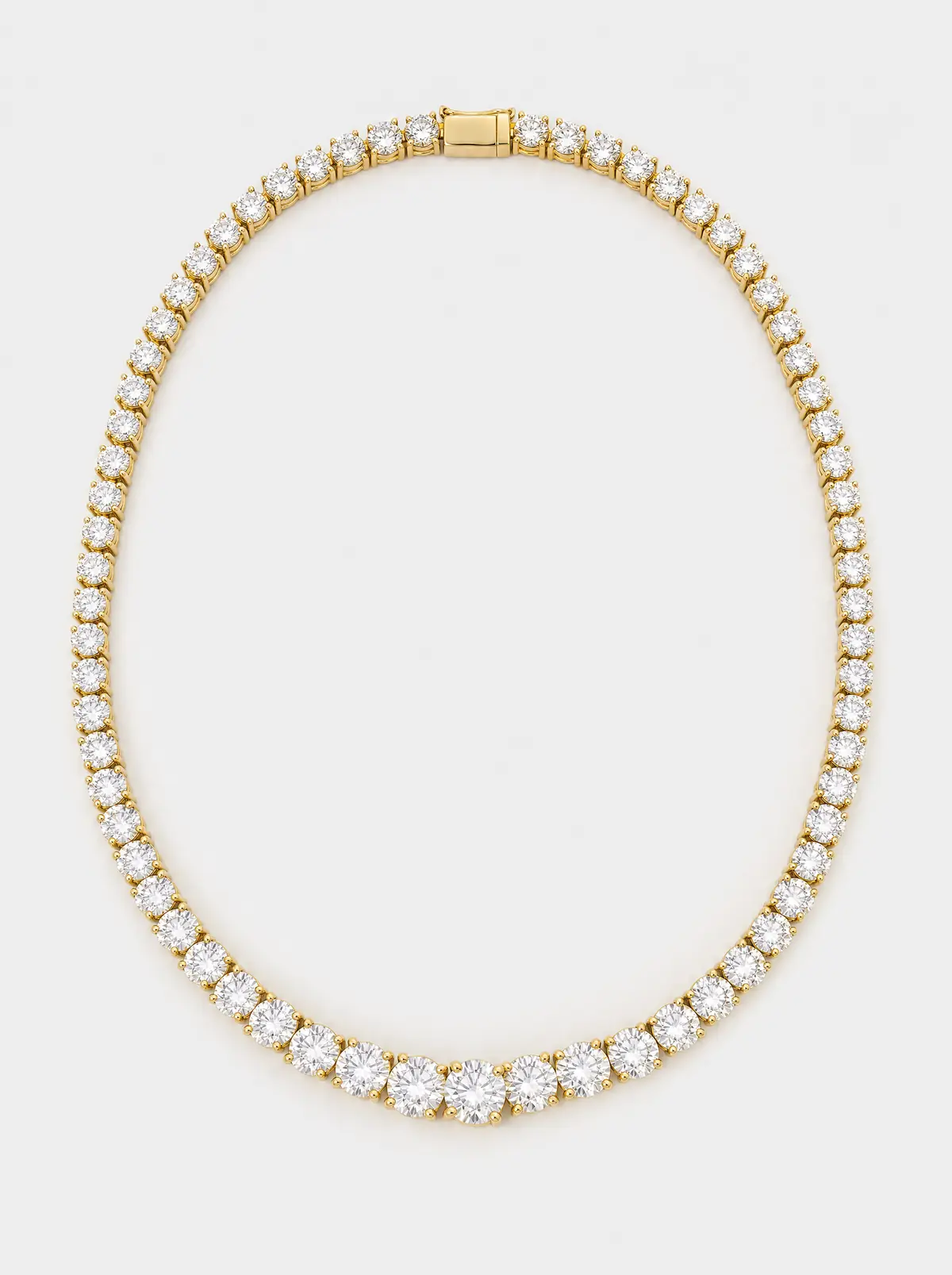 A yellow-gold graduated diamond riviera necklace on light grey (illustrative, generated)